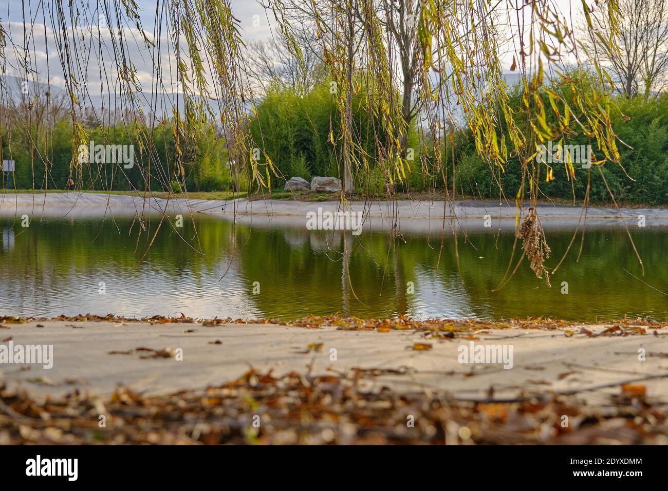 Tema autunnale, alberi secchi marroni e la sua magnificenza riflessione sull'acqua con la gente sulla casa di bambù Foto Stock