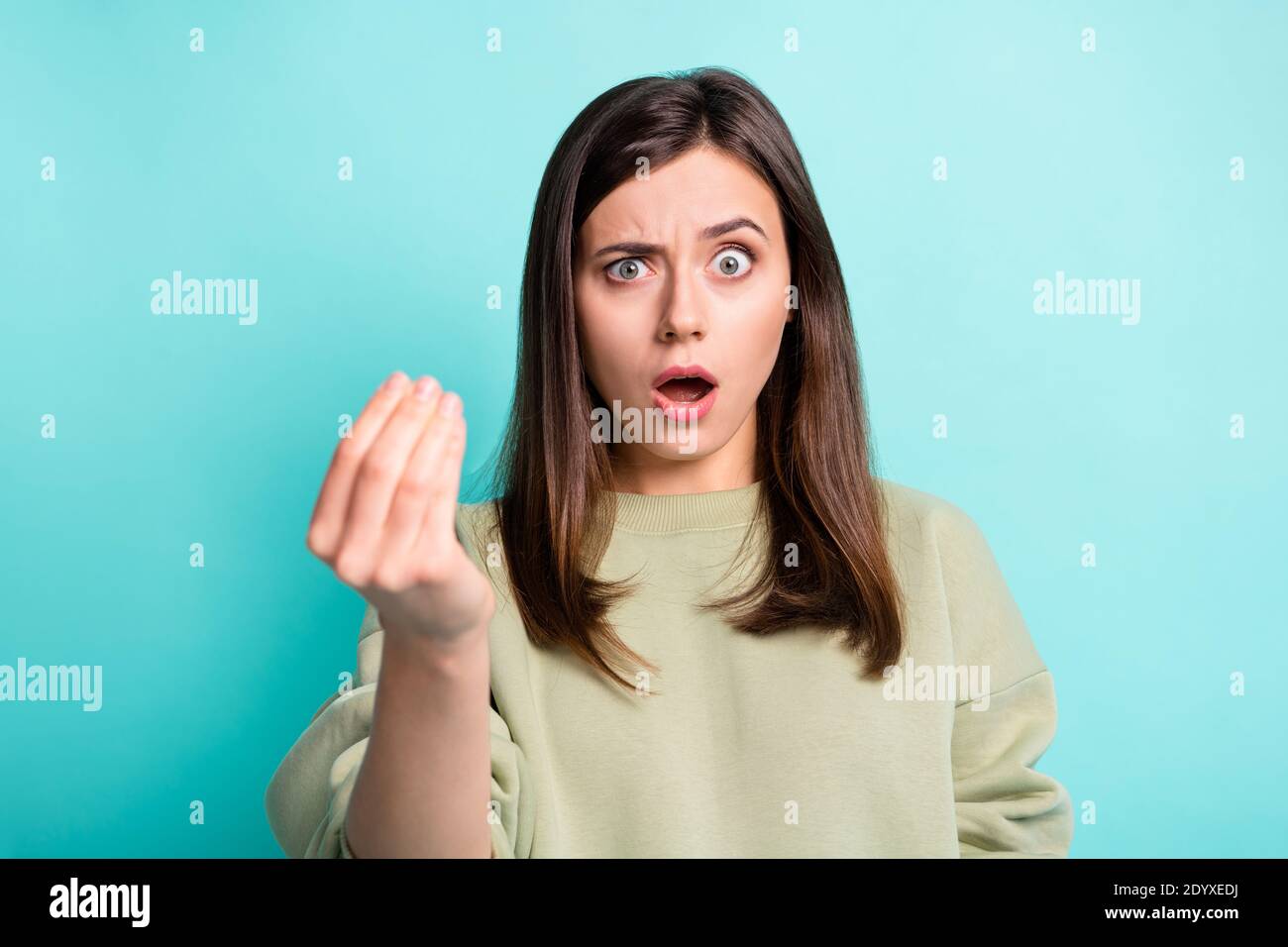 Ritratto fotografico di donna confusa che mostra l'italiano segno mano isolato su sfondo di colore ciano brillante Foto Stock