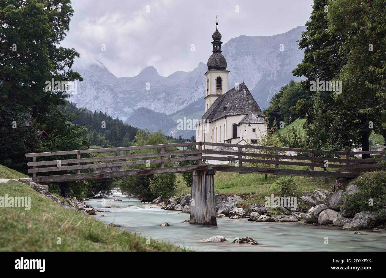 Paesaggio montano con Chiesa Parrocchiale di San Sebastiano e torrente a Ramsau, Germania Foto Stock