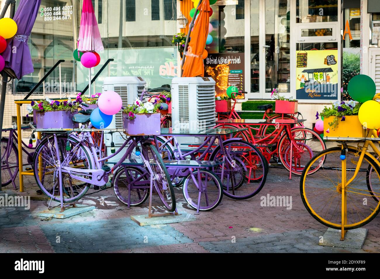 Bicicletta con cesto di fiori colorati accanto a un tè tandoori ristorante Foto Stock