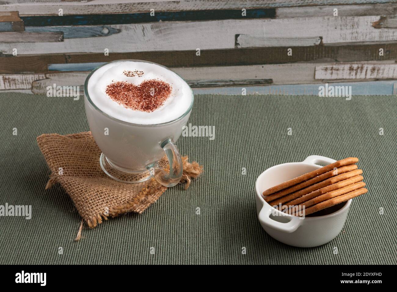 Primo piano di una superficie da tavolo a forma di cuore latte e biscotti Foto Stock
