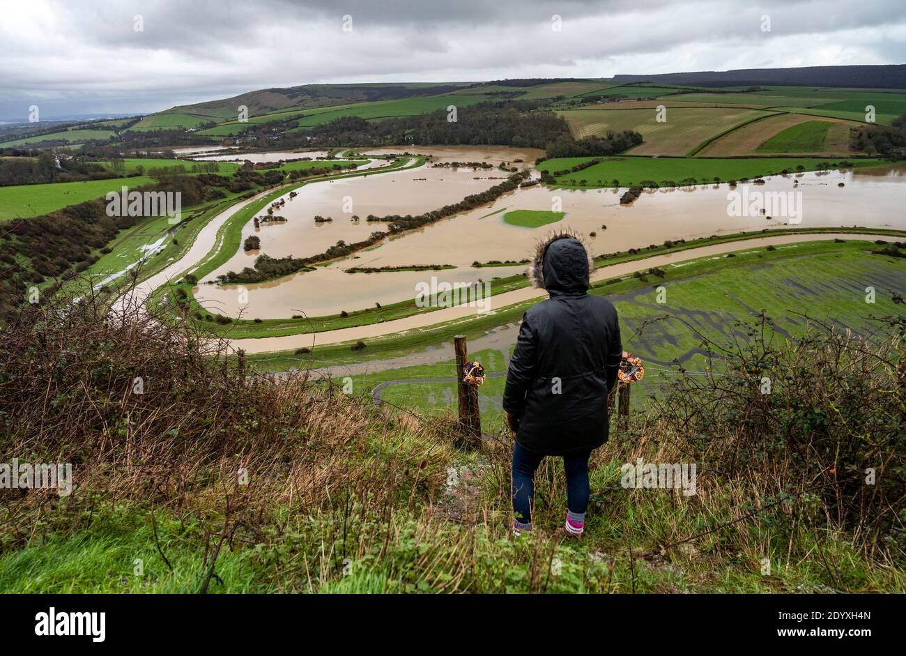 Alfriston Sussex UK 28 dicembre 2020 - UN camminatore si ferma per guardare attraverso i campi e terreni agricoli che sono allagati dal fiume Cuckmere vicino Alfriston nel Sussex orientale dopo la recente pioggia pesante e Storm Bella che ha causato la rottura in tutto il Regno Unito. Più neve e pioggia sono previste per il Regno Unito nei prossimi giorni: Credit Simon Dack / Alamy Live News Foto Stock