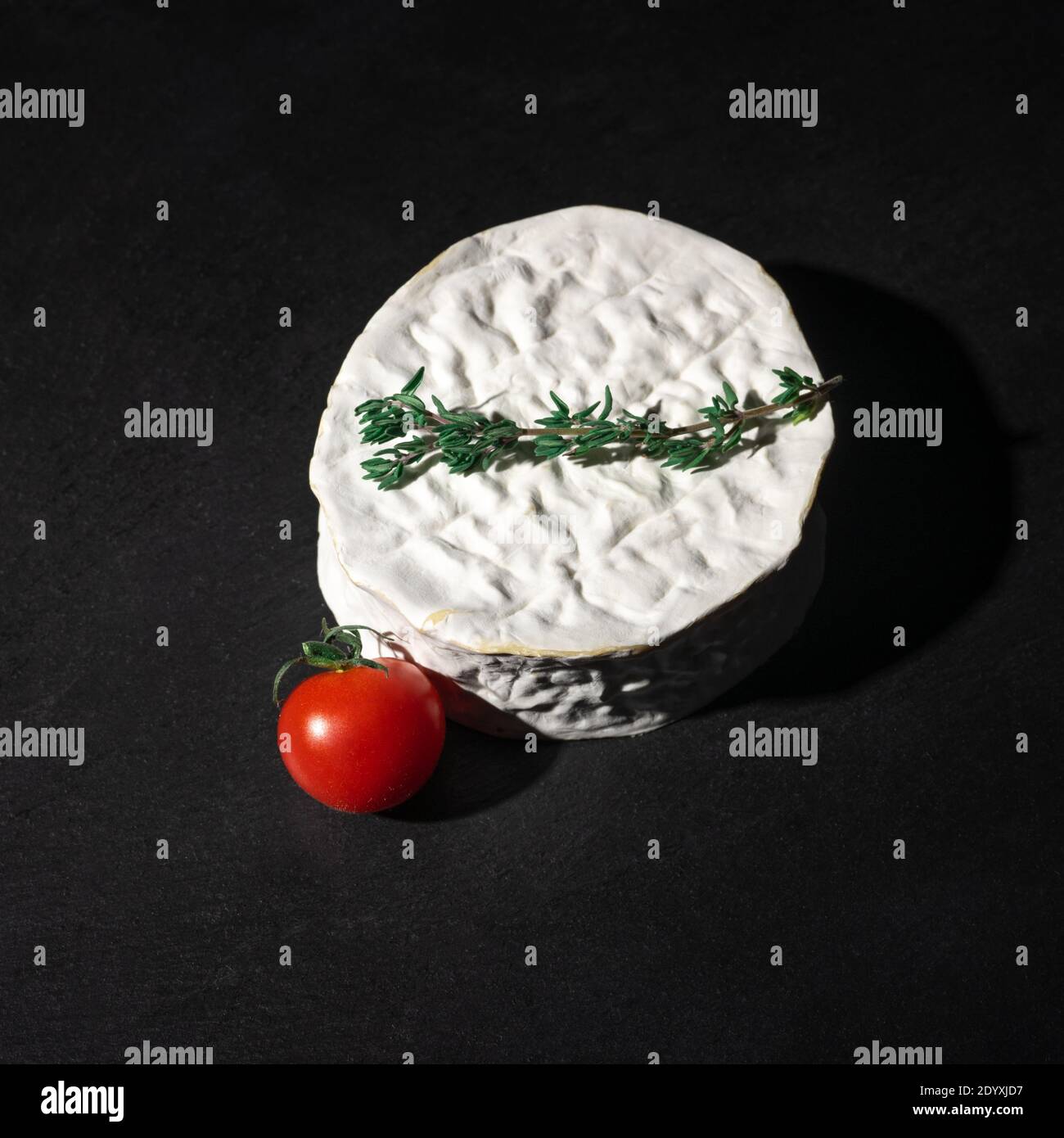 Brie o Camembert Cheese Wheel su tavola nera in ardesia. Immagine quadrata. Delizioso formaggio brie su sfondo nero. Tipo Brie di formaggio. Camembert. Fr. Fresco Foto Stock