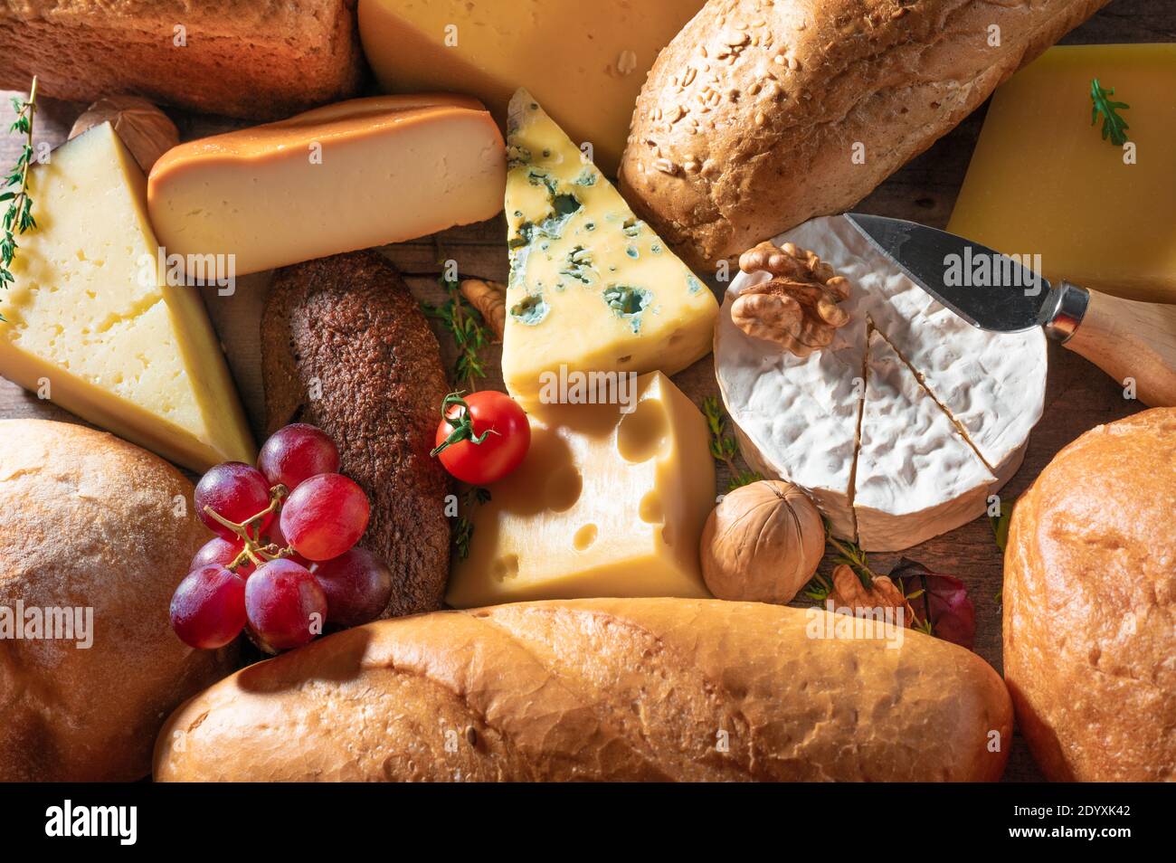 formaggio e pane di fondo. molti tipi di pane e formaggio. piatto di formaggio, degustazione e abbinamento. Un assortimento di vari tipi di formaggio, uva, wal Foto Stock