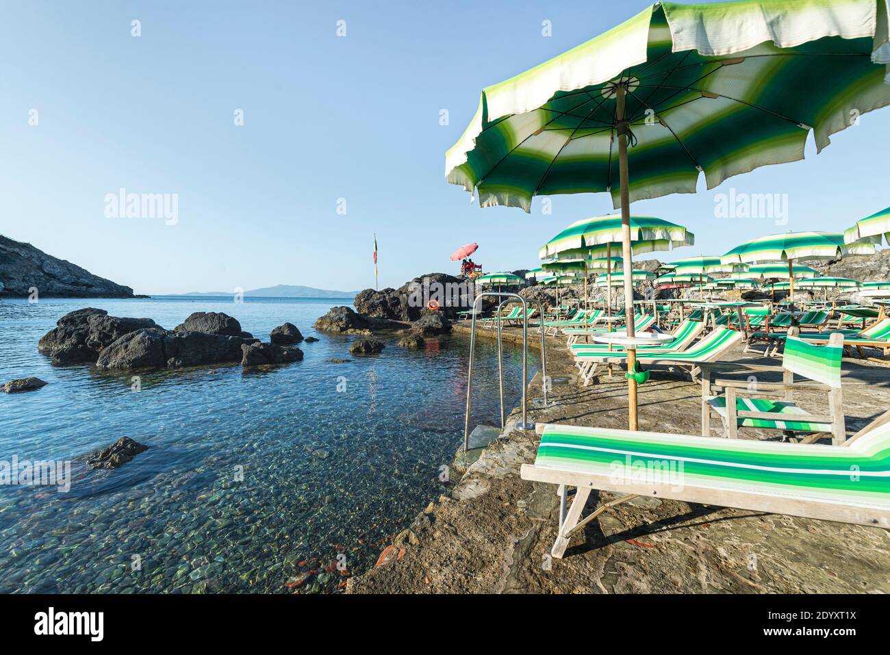 Sedie a sdraio e ombrelloni colorati presso la zona balneare mundane bagno  delle Donne, sulla costa rocciosa di Talamone, Maremma, Toscana, Italia  Foto stock - Alamy