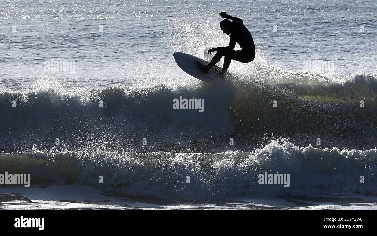 Boscombe, Regno Unito. 28 dicembre 2020. I surfers fanno il la maggior parte della buona onda occasionale su una giornata altrimenti calma ma luminosa e soleggiata alla spiaggia di Boscombe in Dorset. Credit: Richard Crease/Alamy Live News Foto Stock