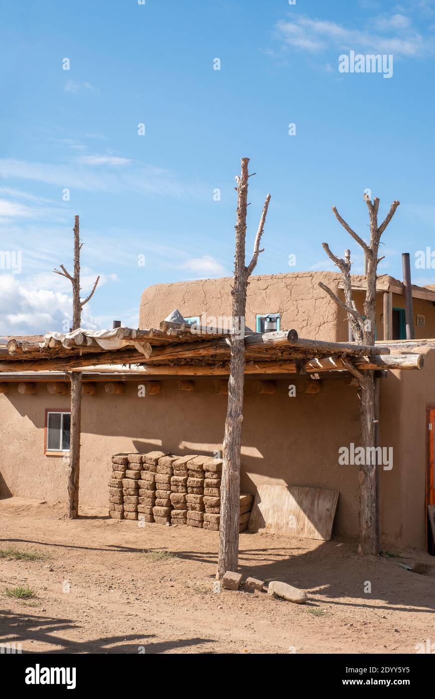 Mattoni di fango di Adobe accatastati accanto a una casa di adobe nello storico villaggio nativo americano di Taos Pueblo, New Mexico, Stati Uniti. Un sito patrimonio dell'umanità dell'UNESCO Foto Stock