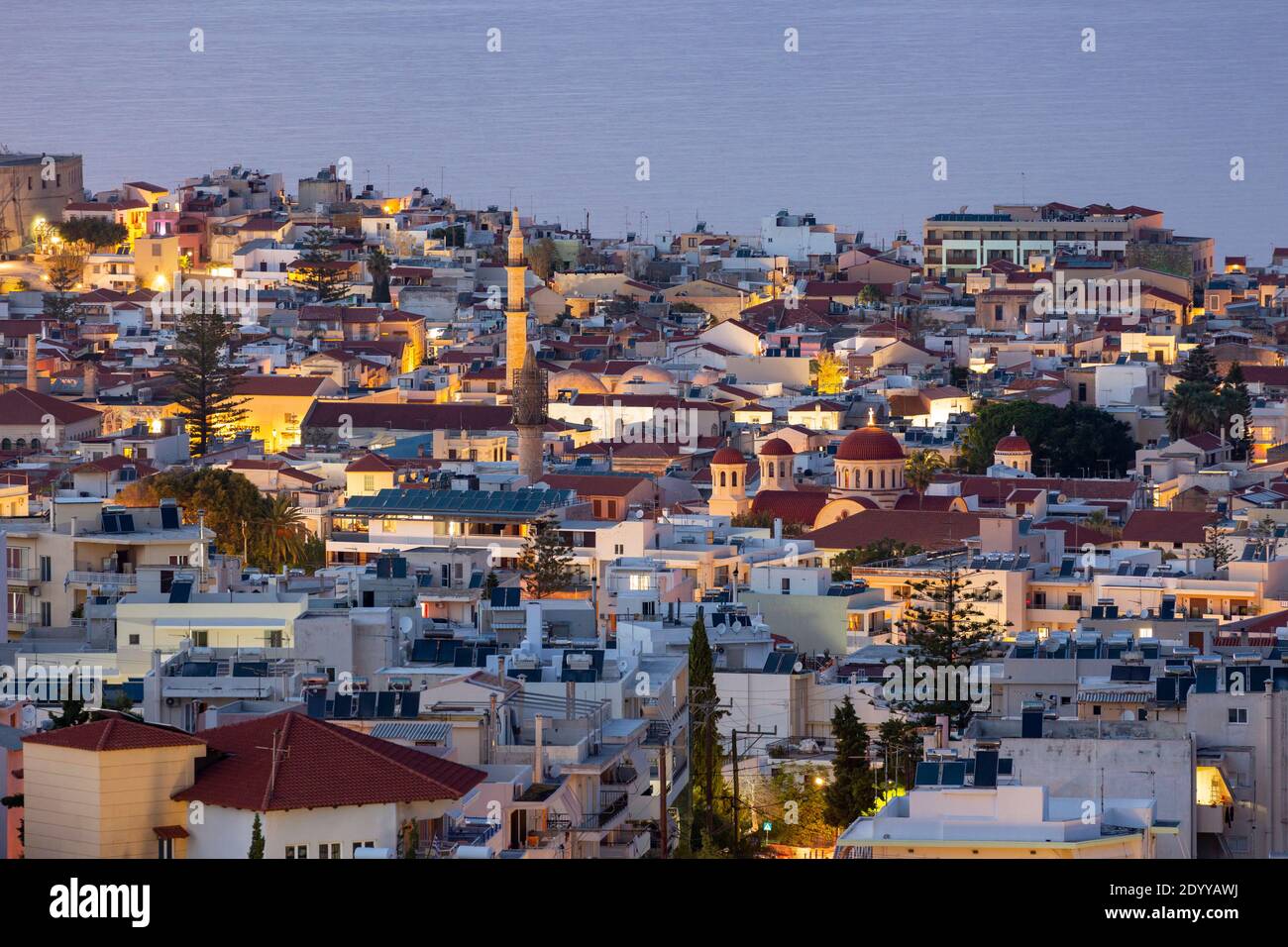 Vista sulla città di Rethymno illuminato al crepuscolo, con minareti e altri luoghi di interesse, Creta, Grecia Foto Stock