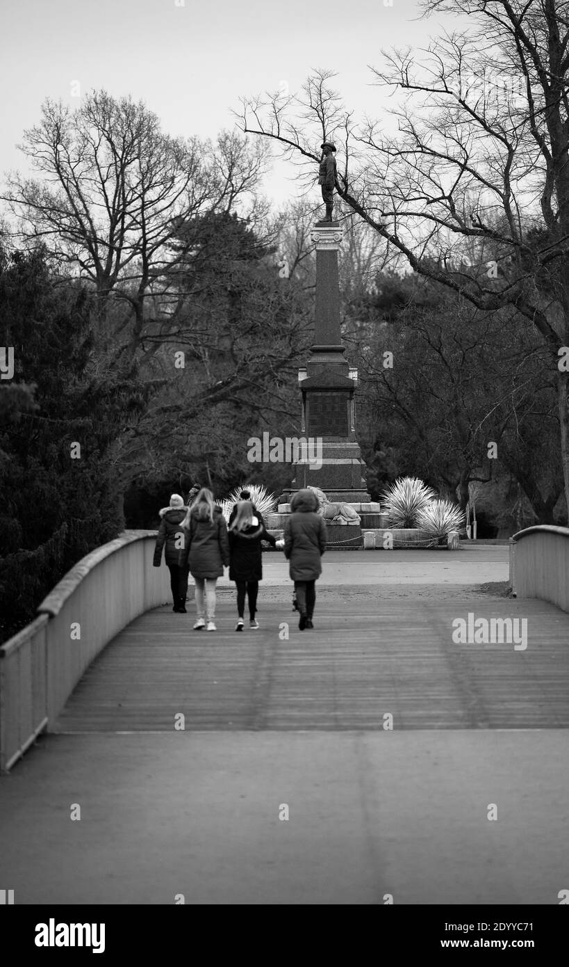 Gruppo familiare che si gode una passeggiata nel parco a Queens Park, Crewe, Cheshire Foto Stock
