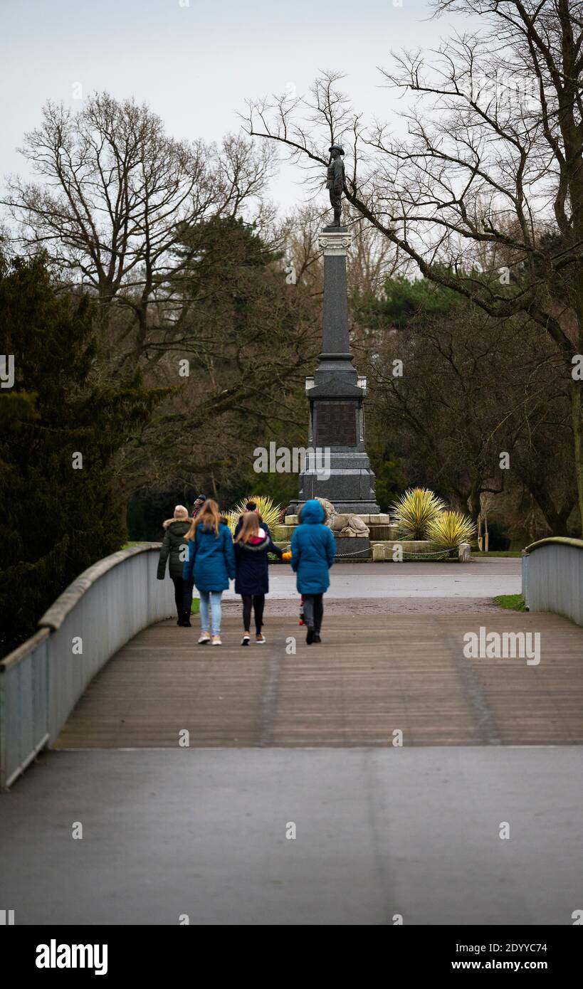 Gruppo familiare che si gode una passeggiata nel parco a Queens Park, Crewe, Cheshire Foto Stock