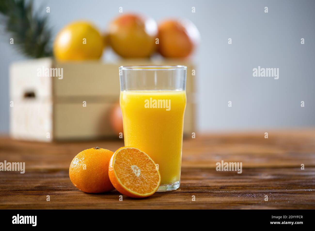 Bicchiere di succo d'arancia sgombato su un tavolo di legno Foto Stock