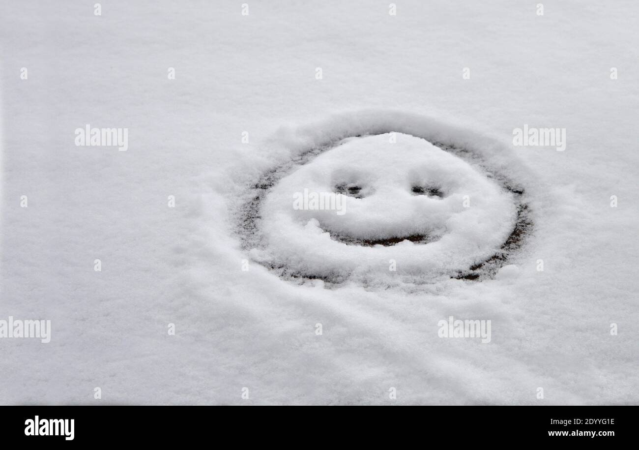Un'emoji fatta nella neve su un tetto Foto Stock