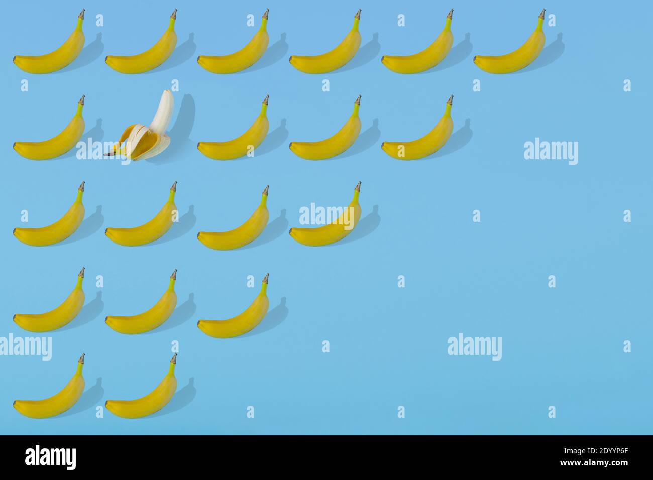Modello estivo alla moda realizzato con frutta fresca di banana su sfondo azzurro luminoso. Concetto estivo minimo. Foto Stock