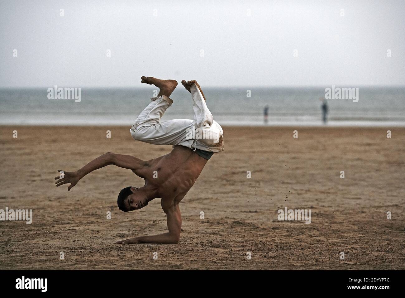 MAROCCO /Essaouira / giovane uomo che balla sulla spiaggia Foto Stock