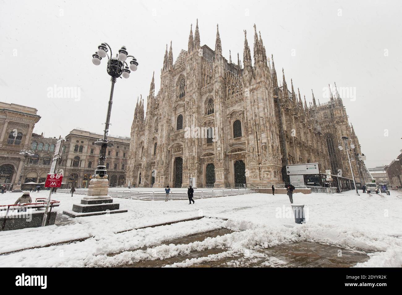Milano, Italia - 28 dicembre 2020: via di Milano durante la neve di fine dicembre, le persone sono visibili in lontananza. Foto Stock