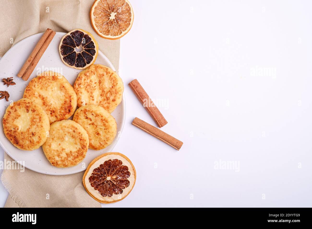 Frittelle di formaggio di cottage. Umore per la colazione di Natale con anice e cannella su sfondo bianco, spazio copia vista dall'alto Foto Stock