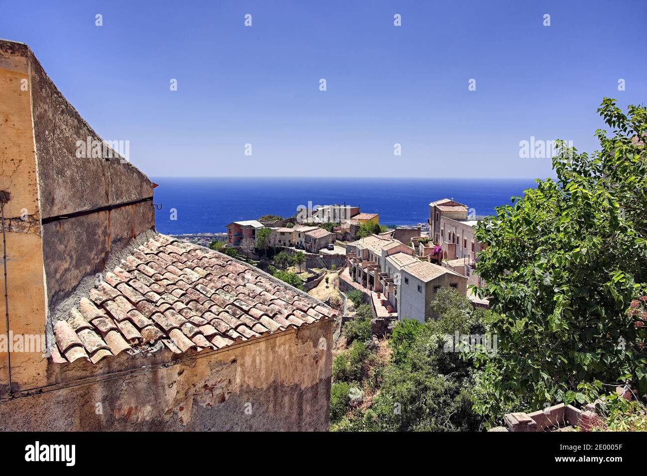 Savoca città collinare in Sicilia e mare blu sullo sfondo sono testimonianze dell'architettura siciliana e della natura Foto Stock