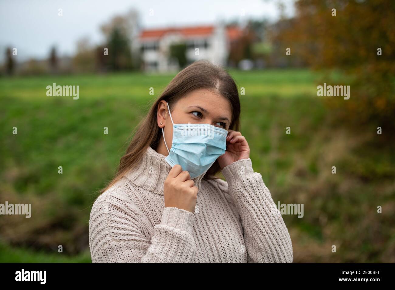 giovane donna nel parco indossa una maschera protettiva durante la pandemia covid-19, stagione autunnale Foto Stock giovane donna nel parco indossa una maschera protettiva durante la pandemia covid-19, stagione autunnale Foto Stock