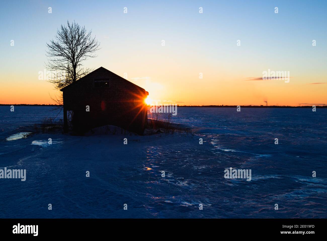 Paesaggio con shack abbandonato in inverno al tramonto Foto Stock
