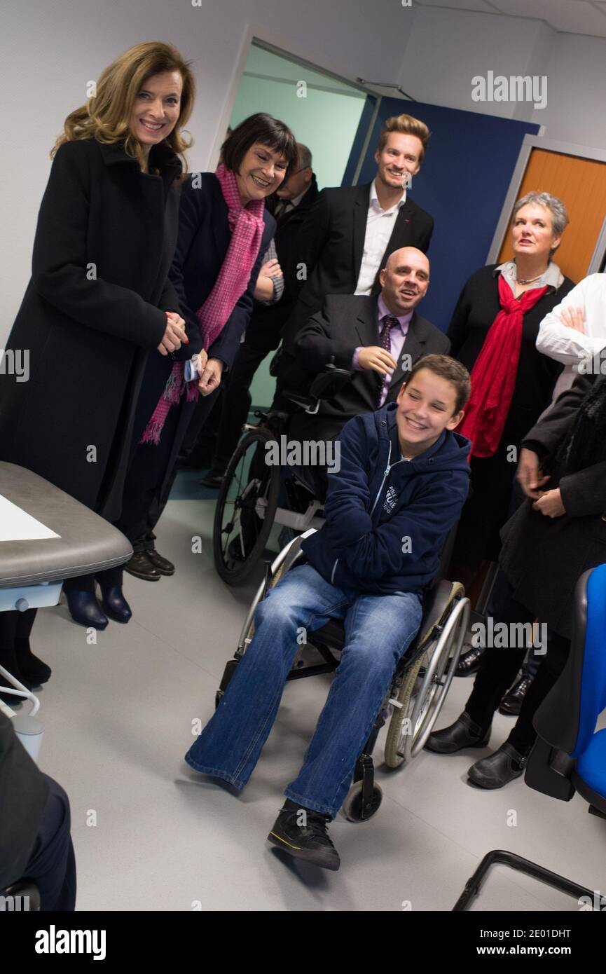 La compagna del presidente francese Valerie Trierweiler e Marie-Arlette Carlotti posa con Theo, un amputato di 13 anni a 4 arti, come parte della sua visita il 27 novembre 2013 a Vichy, Francia centrale. Theo è un titolare di sovvenzione del ramo sportivo disabili del Centro francese di competenza e prestazioni Ressource (CREPS) di Vichy Auvergne, dove si allena in nuoto. All'inizio del 2013, ha gareggiato per la prima volta nei campionati francesi di nuoto disabili. Foto di Christophe Guibbaud/ABACAPRESS.COM Foto Stock