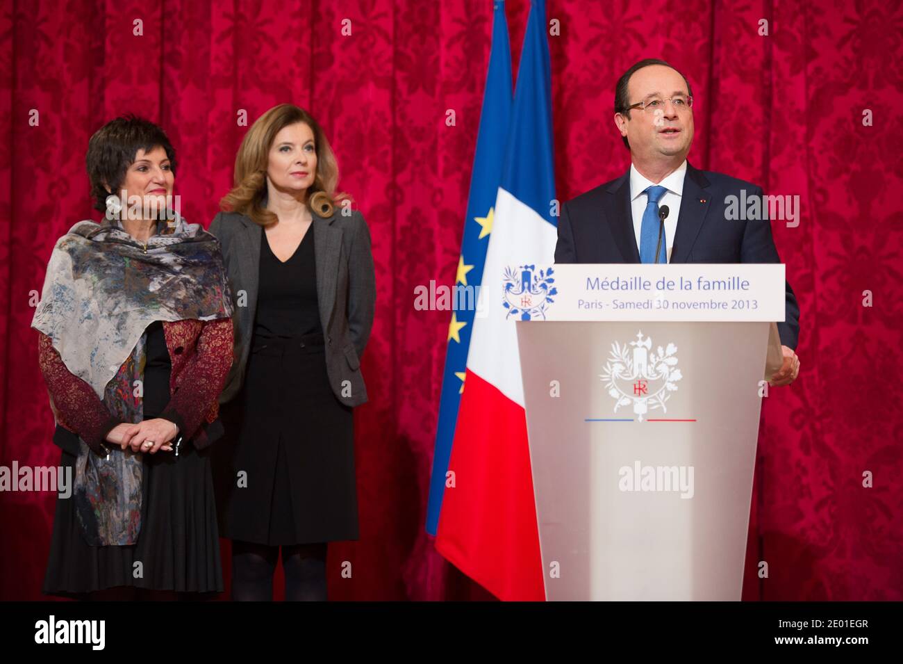 Il presidente francese Francois Hollande ha tenuto il suo discorso seguito dalla sua compagna Valerie Trierweiler e dal Ministro Junior per i disabili Marie-Arlette Carlotti durante la cerimonia annuale di premiazione della Medaille de la Famille Francaise, presso il Palazzo Elysee di Parigi, in Francia, il 30 novembre 2013. Il premio è quello di onorare quanti con successo hanno allevato molti bambini con dignità. Foto di Nicolas Gouhier/ABACAPRESS.COM Foto Stock