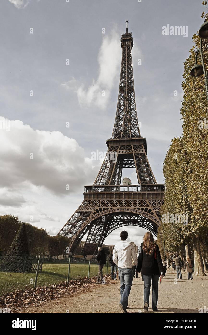 FRANCIA / Ile de France / Parigi / Coppia a piedi con la Tour Eiffel in lontananza. Foto Stock