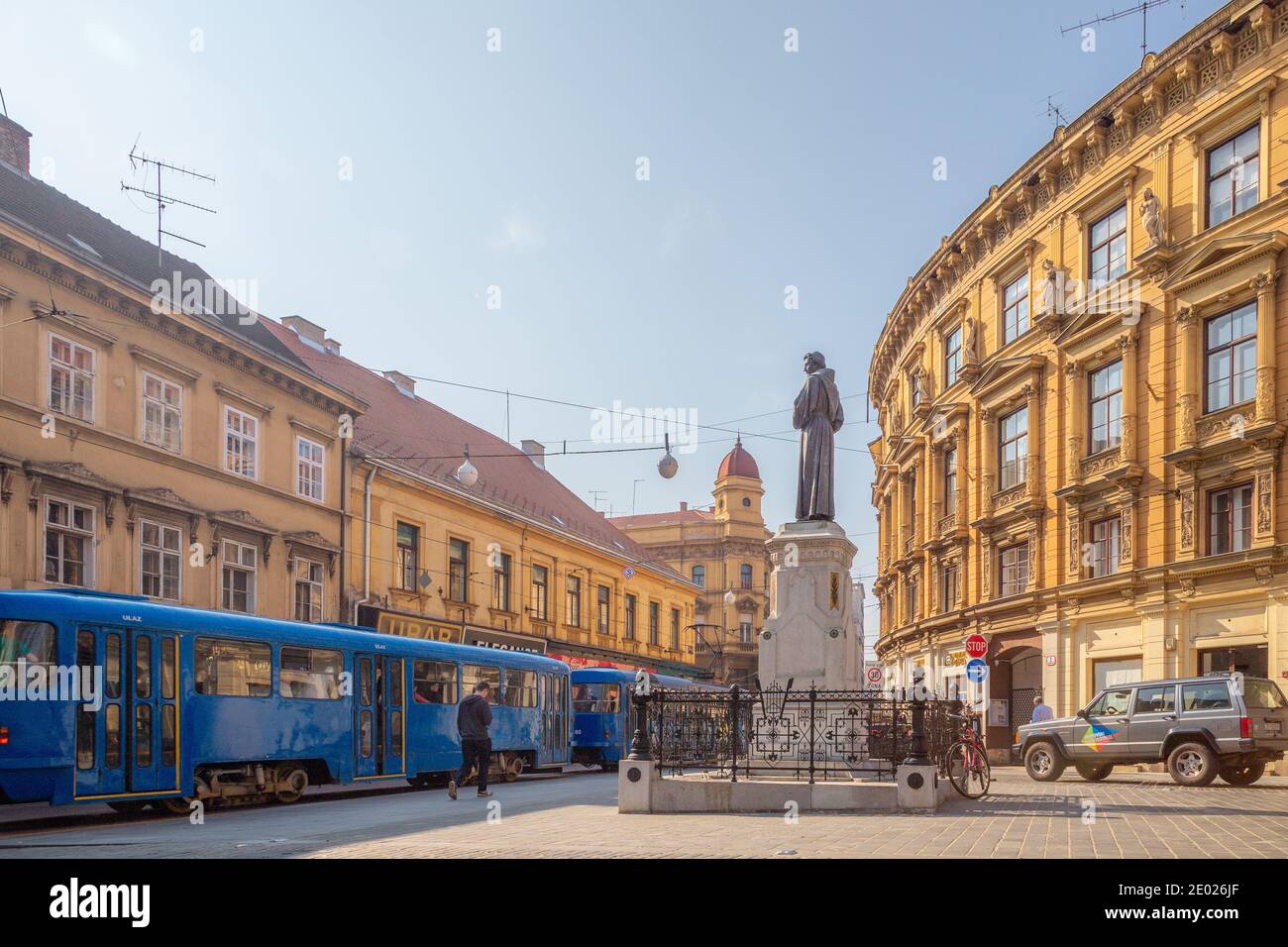 Zagabria, Croazia - 7 ottobre 2014: Un tram zips da una statua nel centro di Zagabria, la capitale della Croazia. Foto Stock