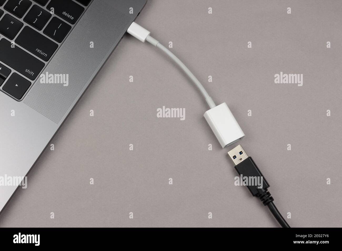 un adattatore usb-c a usb collegato a un computer con un cavo usb accanto ad esso in attesa di essere inserito, un modo per utilizzare dispositivi usb su computer che non lo fanno Foto Stock