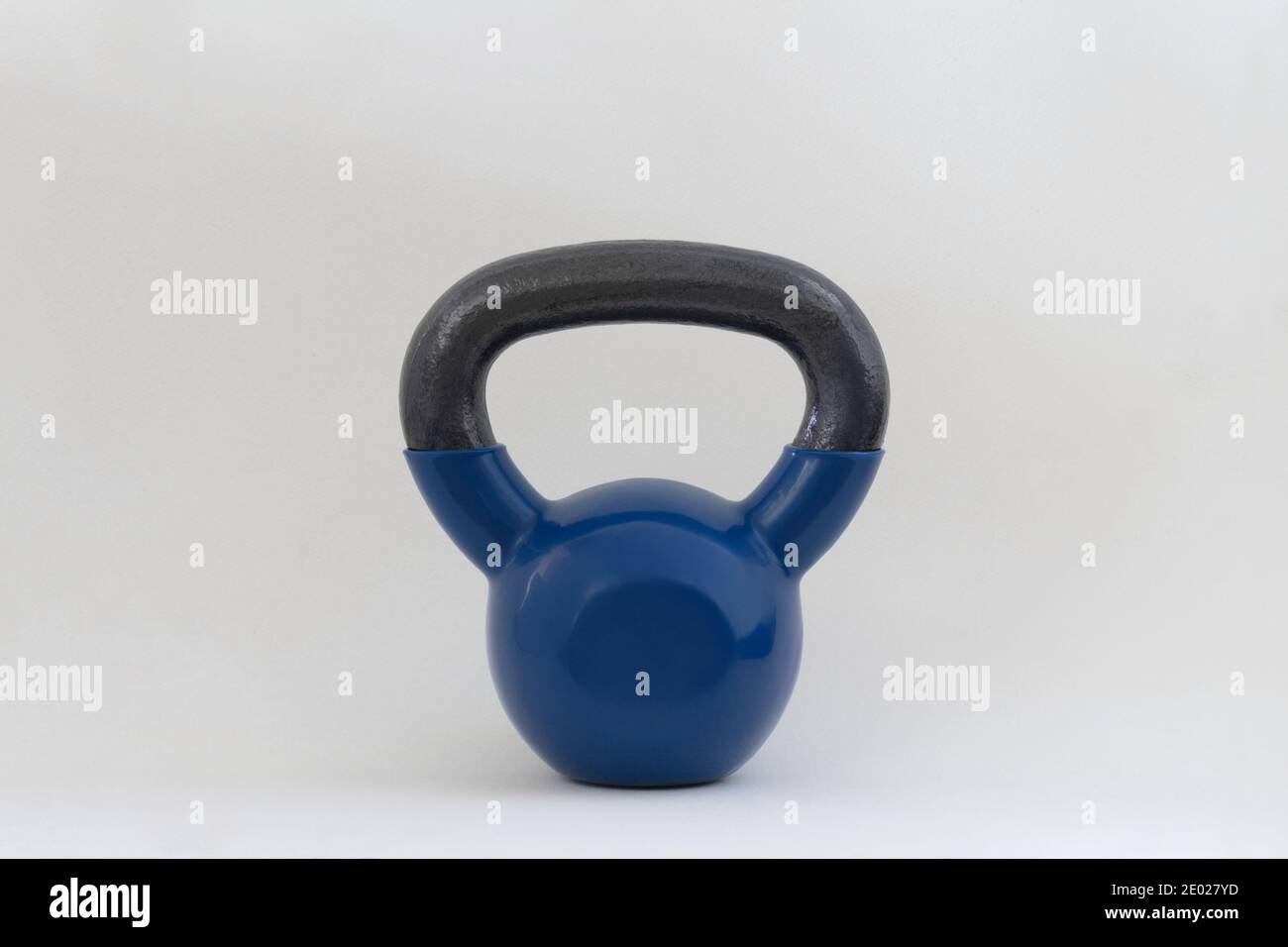 un singolo peso blu kettlebell in per il fitness domestico su uno sfondo bianco, con spazio di copia Foto Stock