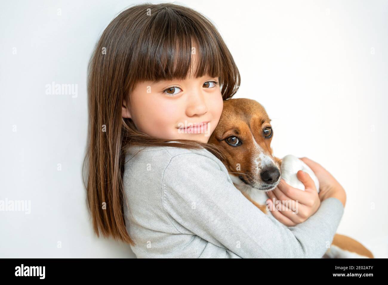 Ragazza di otto anni abbracciando il suo cane animale domestico Foto Stock
