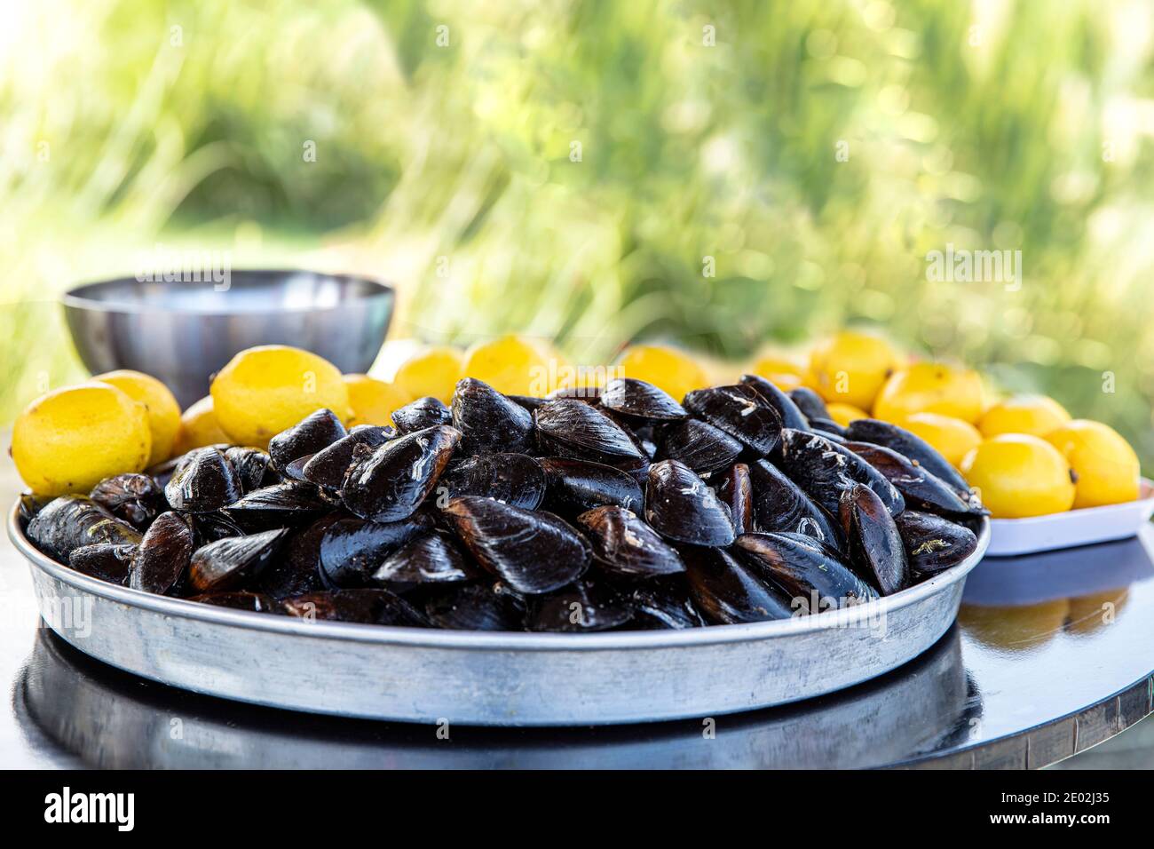 Cozze cotte. Cozze in salsa al limone. Prodotti del mare. Negozio di musiche, cozze miste e stativo di musella con limoni. Foto Stock