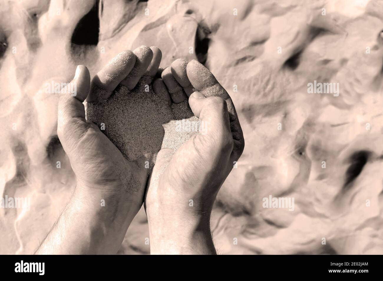 sabbia in mani di mans. deserto sfondo Foto Stock