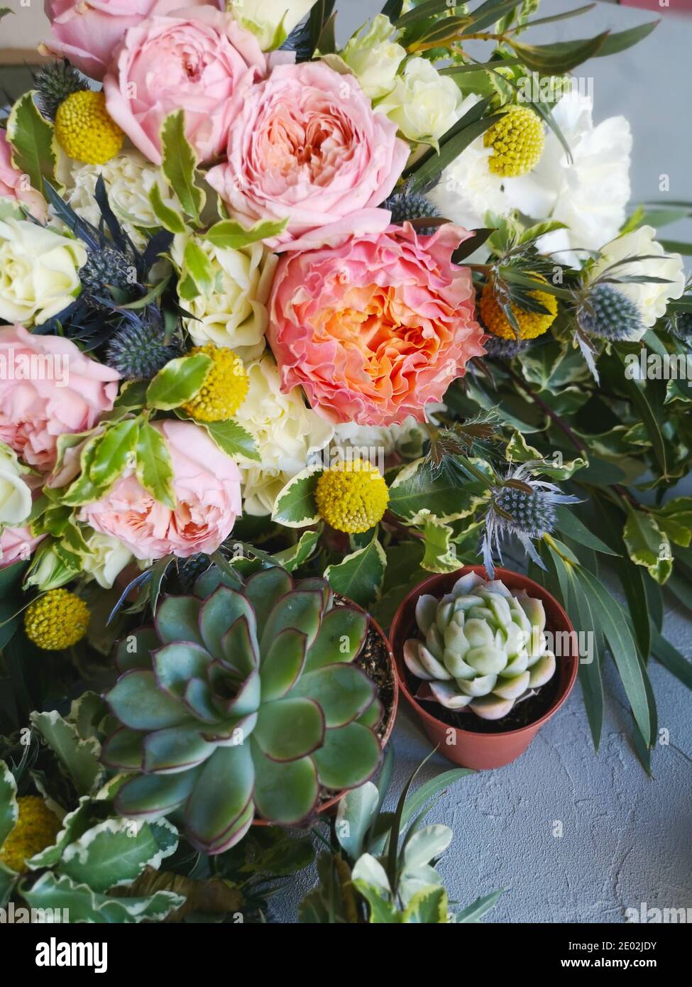 Fiori e succulenti. Bouquet nuziale su tavola fiorista. Stile di vita, vista dall'alto Foto Stock