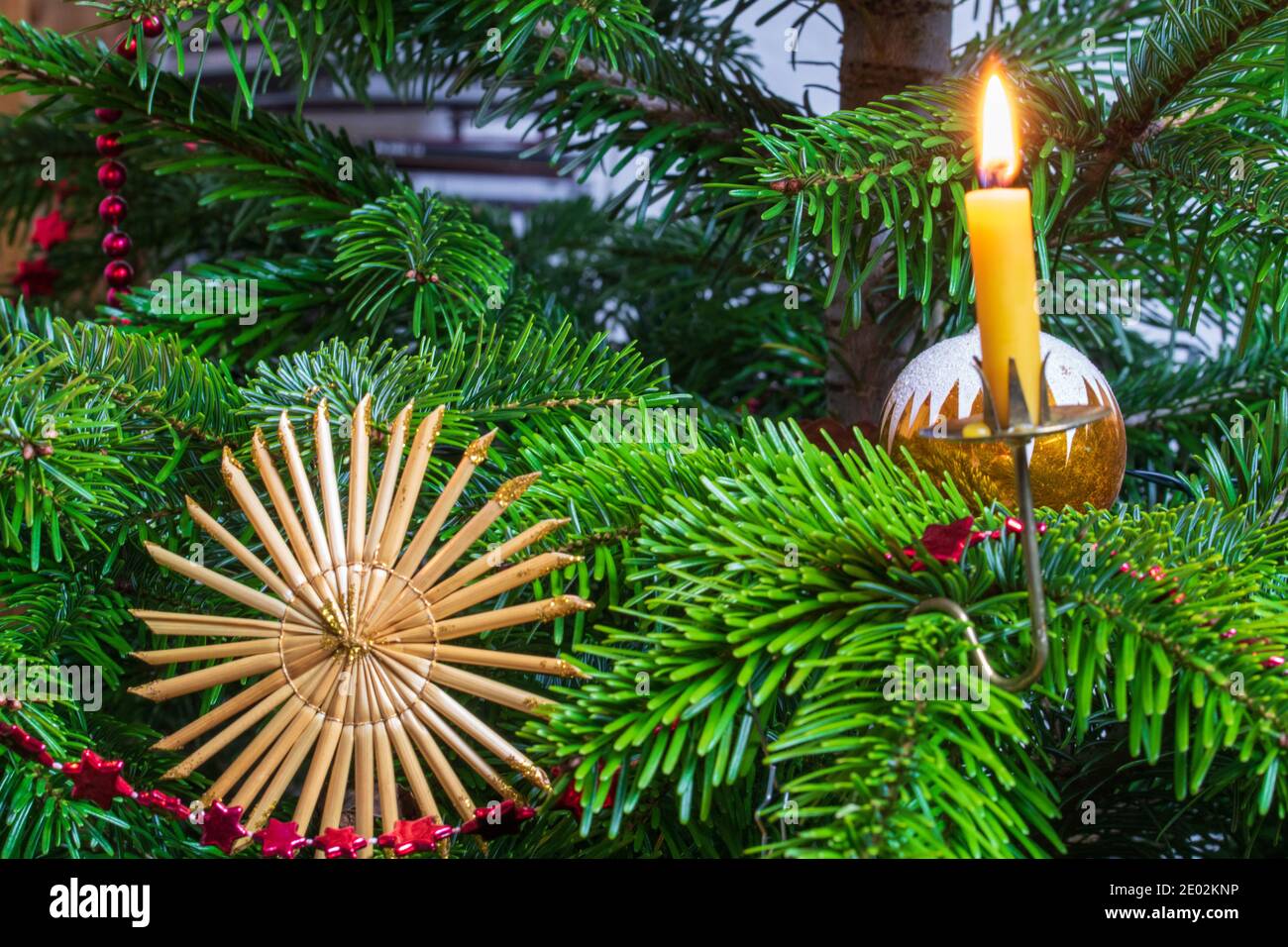 Decorazioni natalizie e candele di cera d'api sull'albero di Natale. Foto Stock
