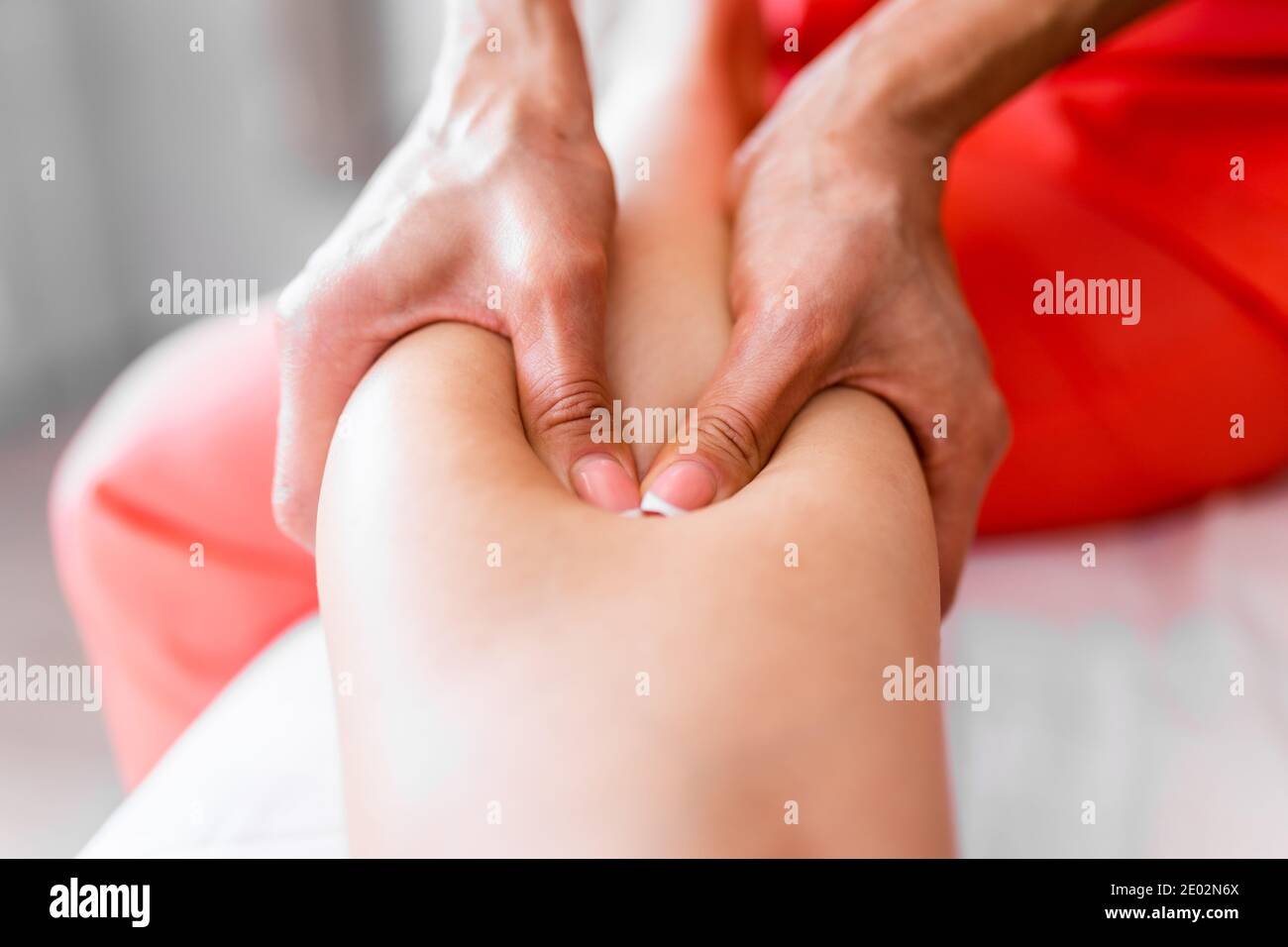 Le mani delle donne massaggiano le gambe e gli shins dell'atleta dopo la concorrenza. Massaggio sportivo, recupero. Medicina dello sport. Flebeurisma Foto Stock