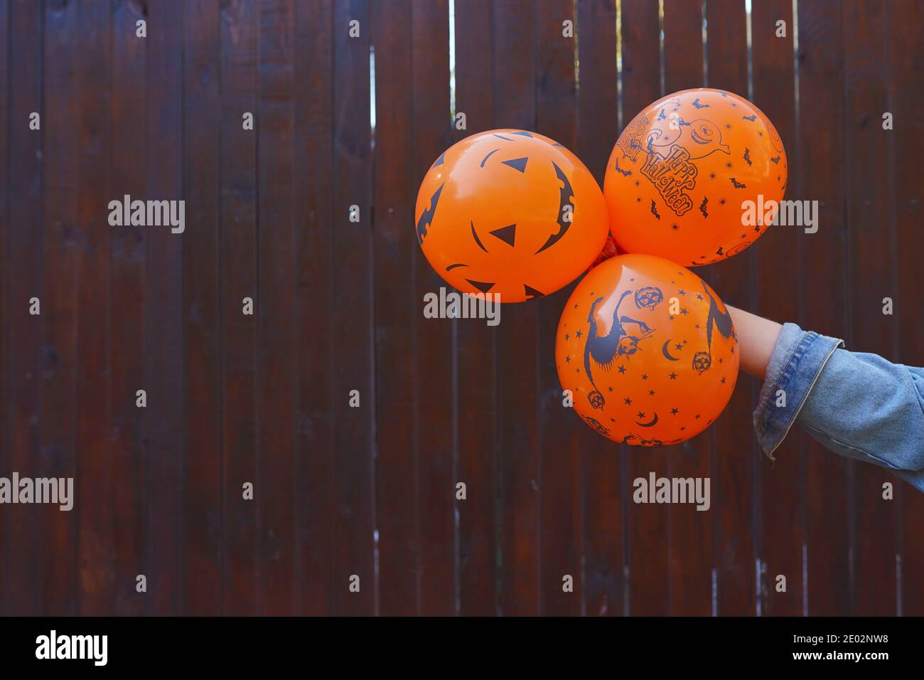 palloncini di halloween nella mano , sfondo marrone spazio copia Foto Stock