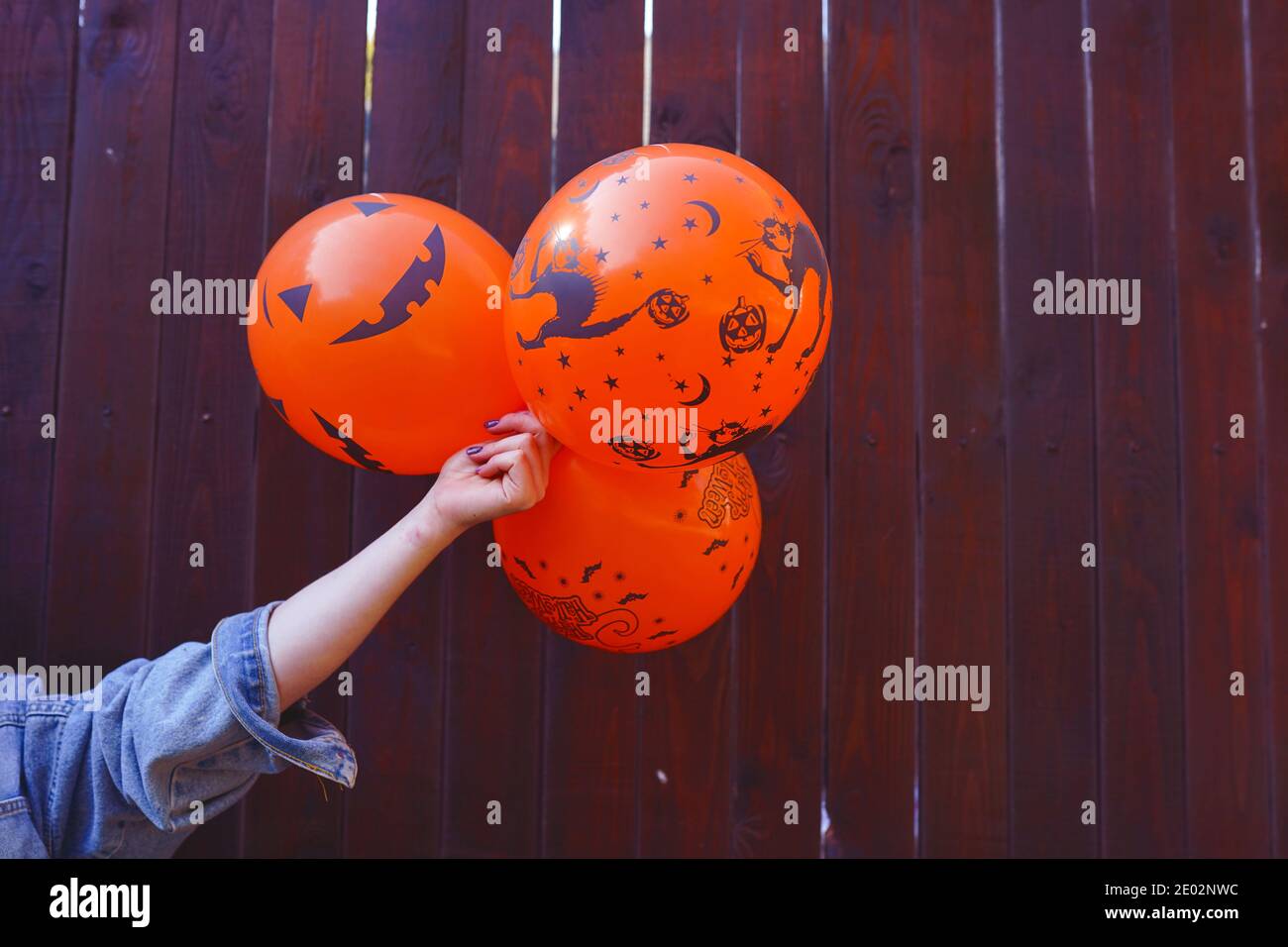 palloncini di halloween in mano, sfondo marrone copia spazio, vacanza Foto Stock