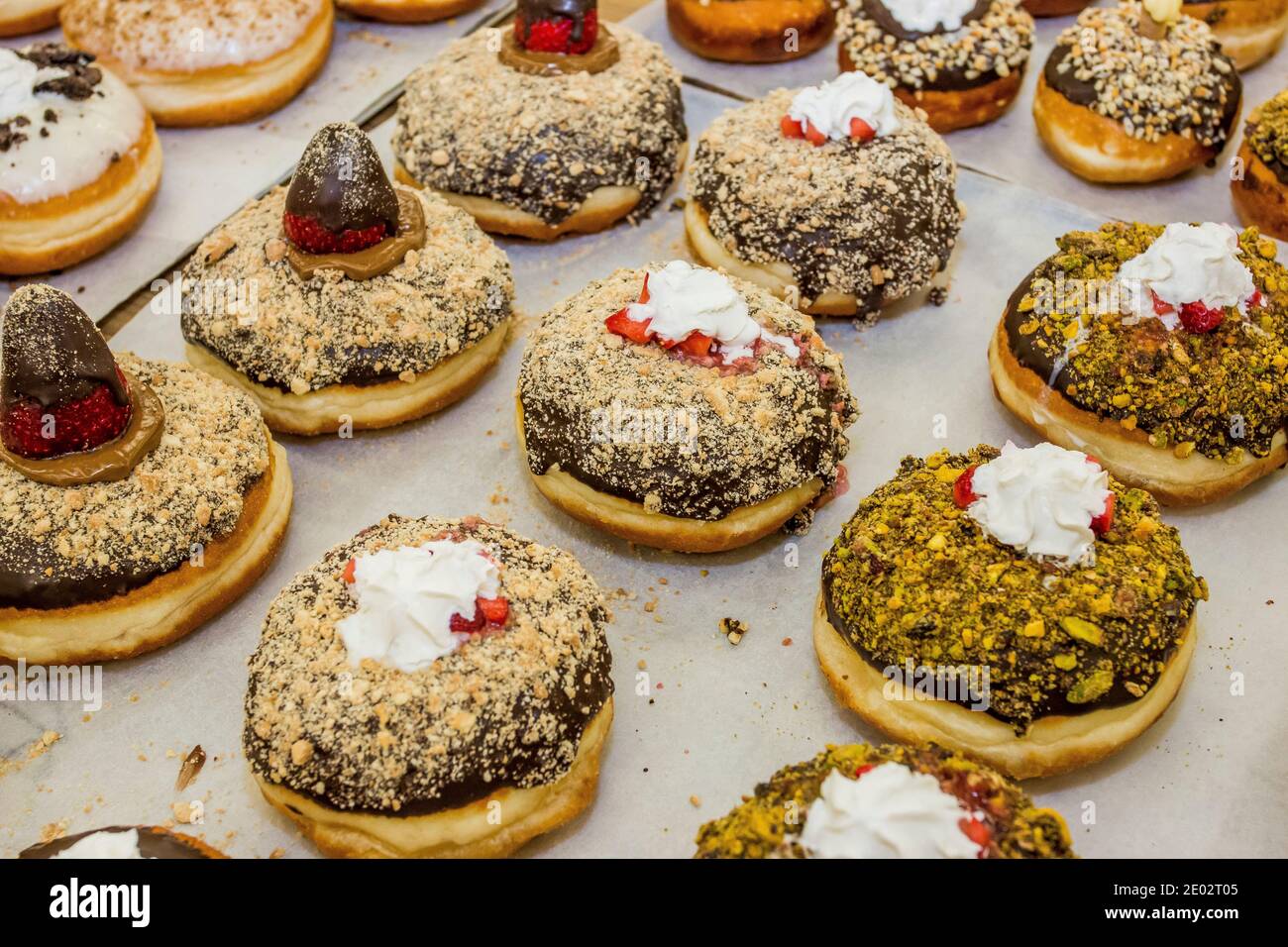 Sufganiyah aromatizzato un tradizionale Donut Ebreo mangiato durante Hannukah con glassatura superiore Foto Stock