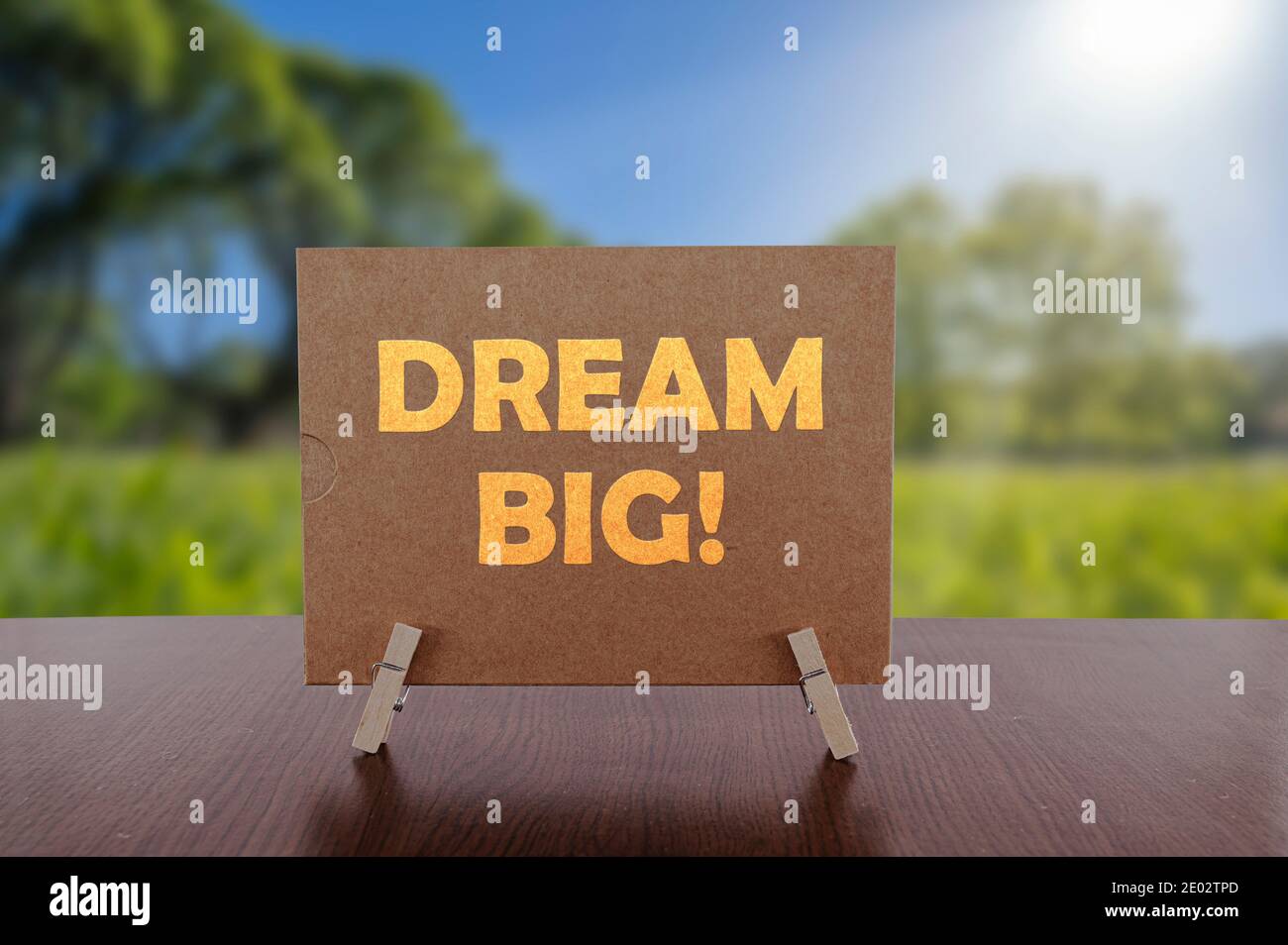 Dream grande testo sulla carta sul tavolo con soleggiato sfondo verde parco. Foto Stock