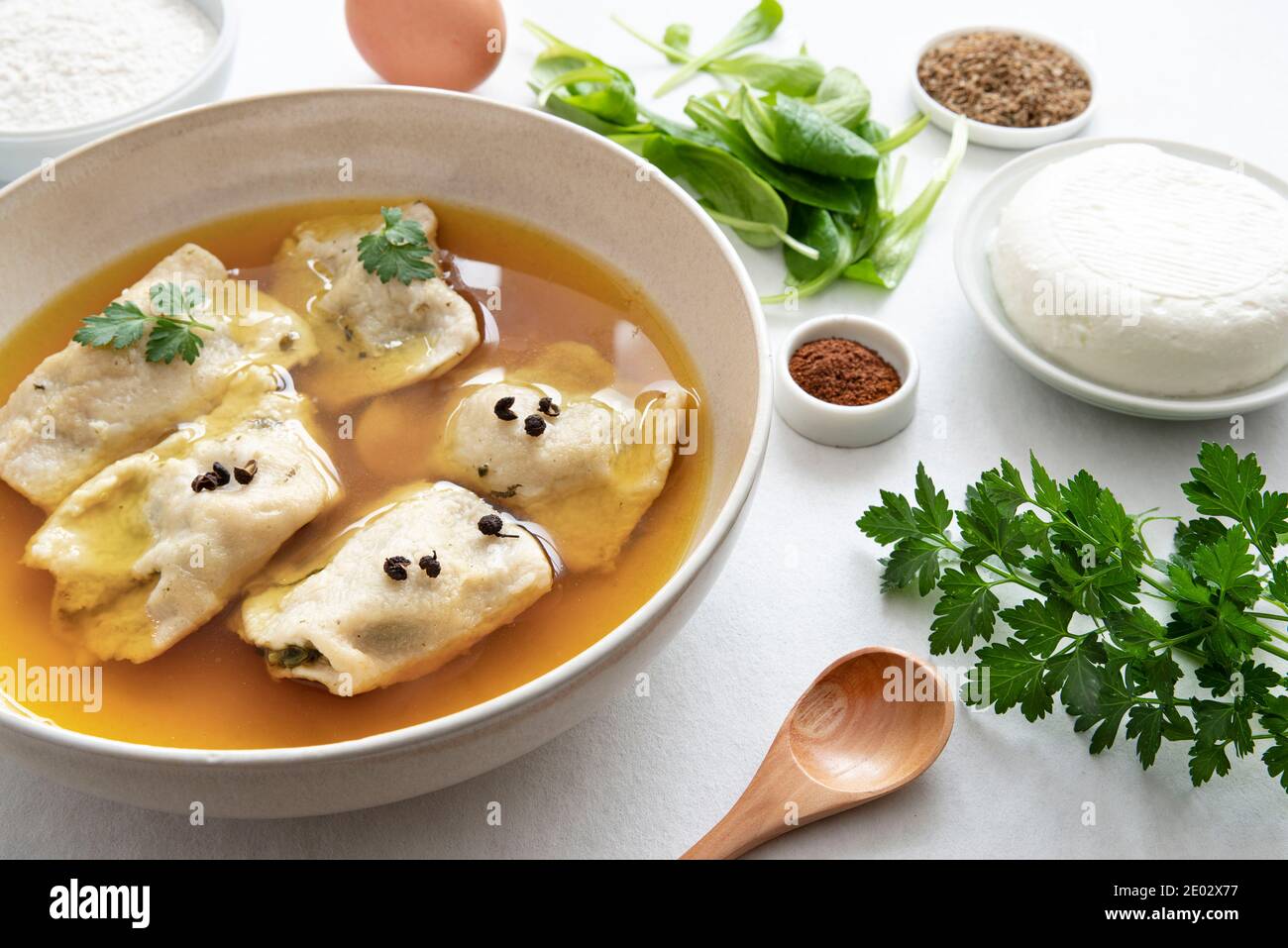 Preparazione di raviole fatte in casa nel proprio brodo con ingredienti intorno ad esso Foto Stock