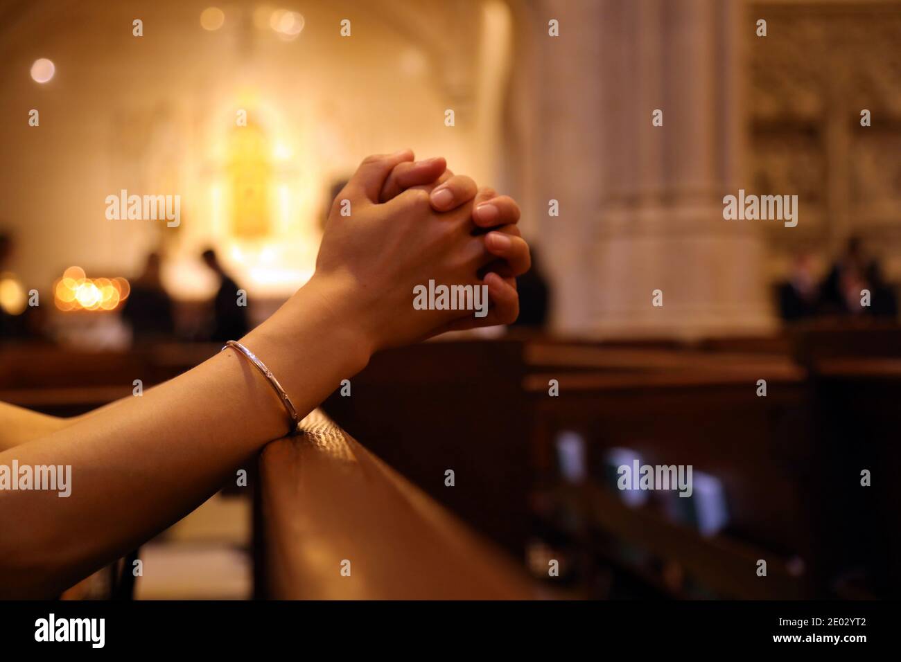 Closeup delle mani della donna che pregano sulla panchina della chiesa, coronavirus, spazio di copia Foto Stock