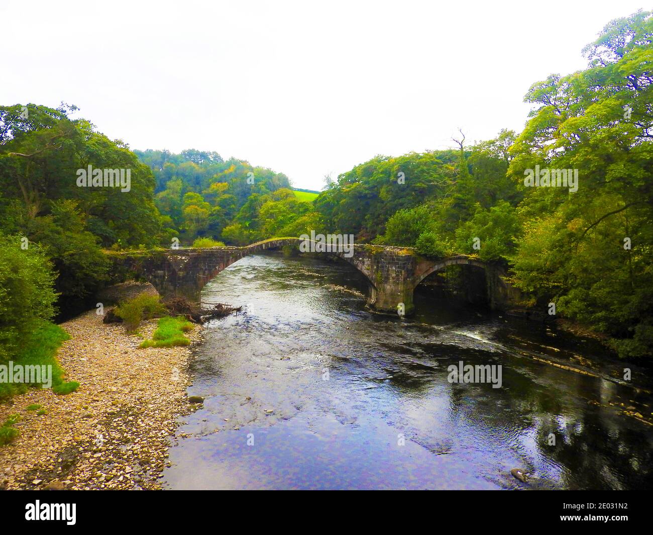 Cromwell's Bridge, Lancaster UK nel 2020. Cromwell's Bridge, Lancashire come era nel settembre 2000. Questo vecchio ponte a cavallo attraversa il fiume Hodder vicino a Hurst Green nella Ribble Valley. Fu costruito c1561 da Sir Richard Shireburn della Stonyhurst Estate (ora Stonyhurst College). Il ponte prende il nome da Oliver Cromwell che ha marciato l'Esercito nuovo modello da Gisburn per combattere i Royalisti nella Battaglia di Preston (agosto 1648). Anche se guardando in rovina, è possibile attraversarlo attraverso un sentiero, anche se il ponte non ha pareti laterali per proteggere gli escursionisti dalla caduta nel fiume Hodder. Foto Stock
