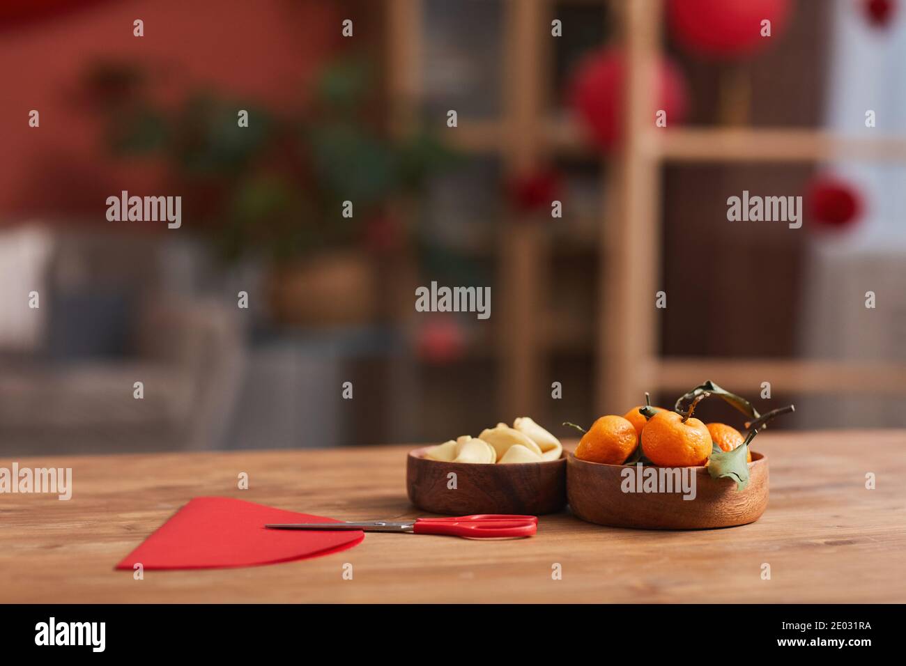 Concettuale nessuna gente ha sparato di tangerini, biscotti di fortuna e carta colorata sul tavolo in soggiorno decorato per la celebrazione cinese di Capodanno Foto Stock