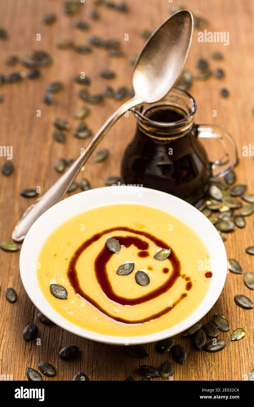 Crema di zuppa di zucca con cucchiaio e olio di semi Foto Stock