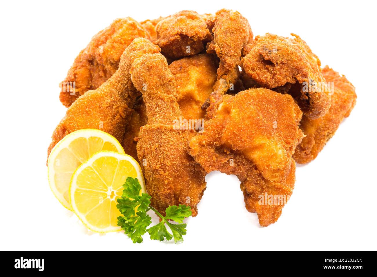 Fritto di pollo a pezzi con limone e prezzemolo isolati su sfondo bianco Foto Stock