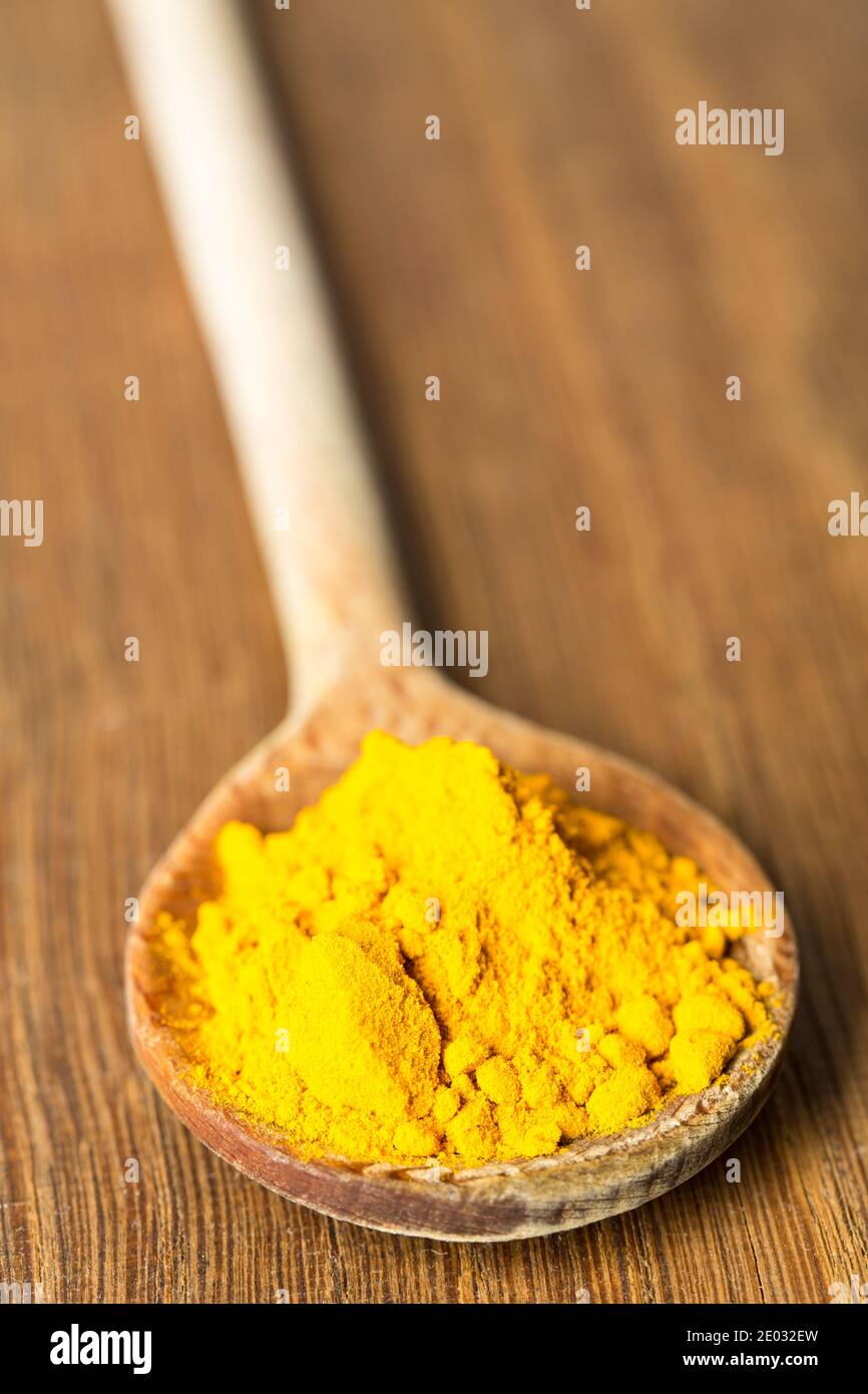 Cucchiaio in legno con curcuma Foto Stock