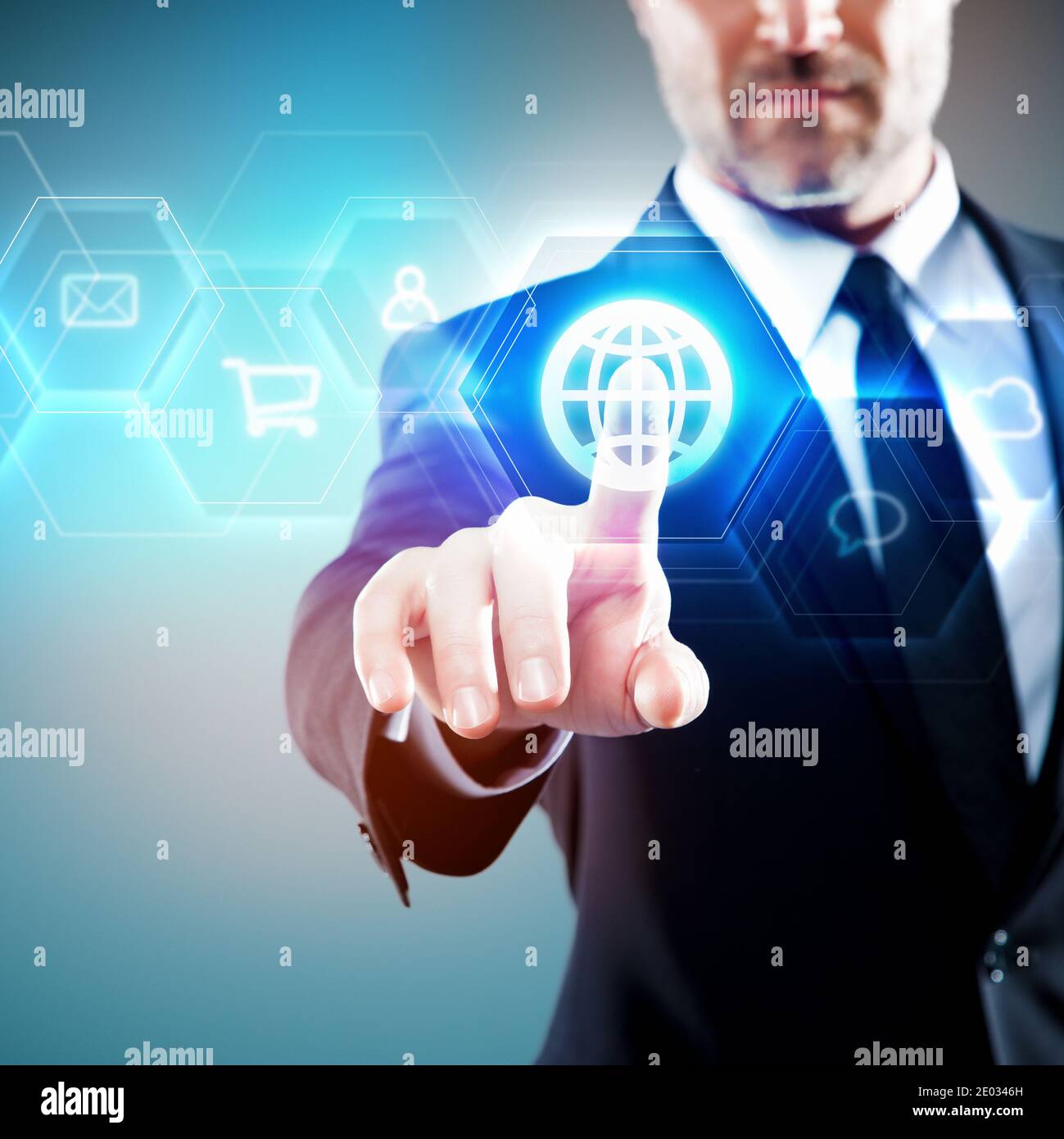 Uomo d'affari che tocca uno schermo digitale futuristico blu, simbolo globale / icona Foto Stock