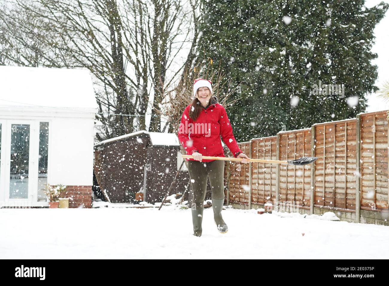 Kidderminster, Regno Unito. 29 Dicembre 2020. Regno Unito tempo: Come più neve continua a cadere attraverso Worcestershire, questa donna sa quando è picchiata e allegra cede su cercando di liberare la neve nel suo giardino di Kidderminster per testa per il calore all'interno! Credit: Lee Hudson/Alamy Live News Foto Stock