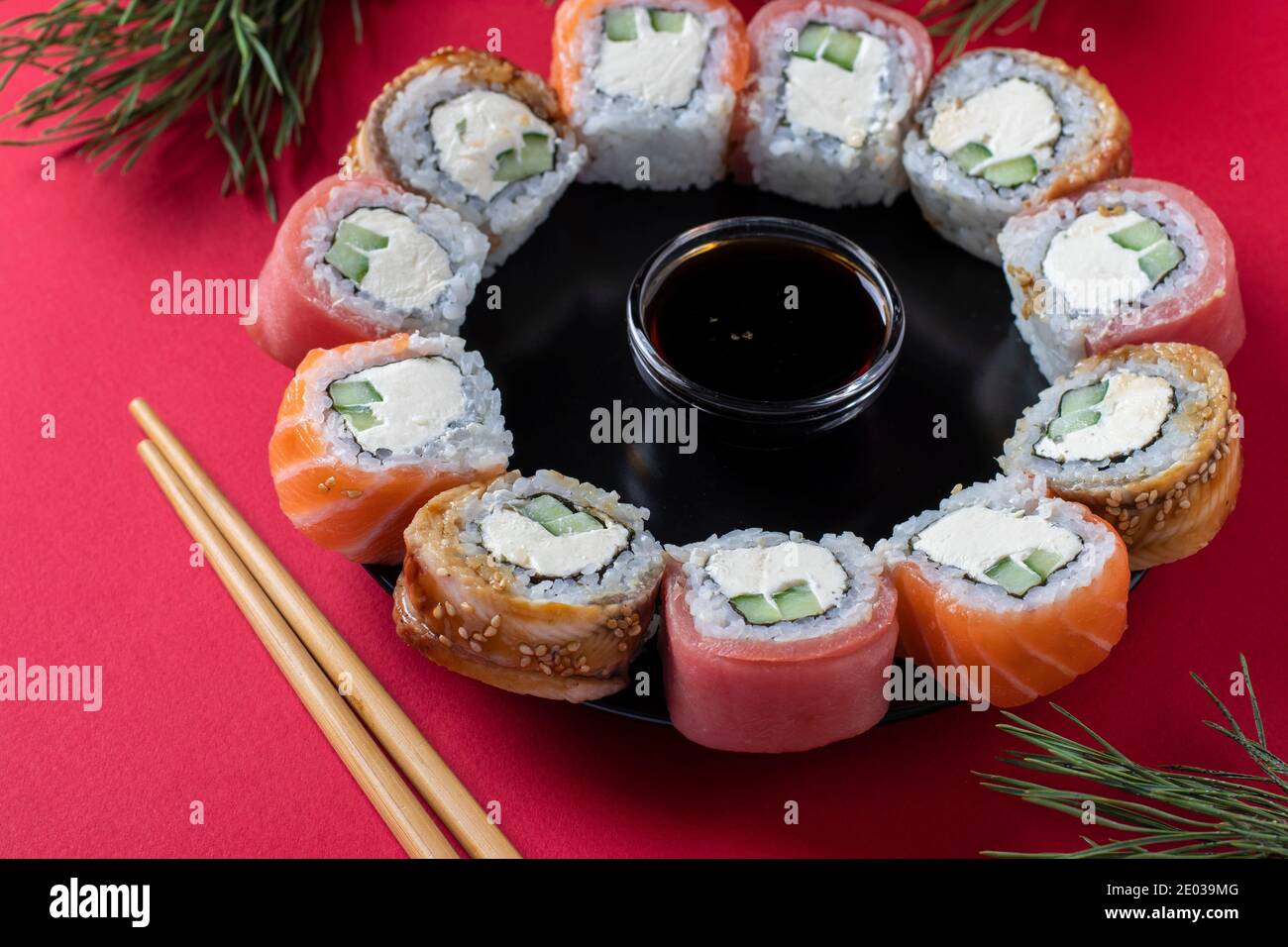 Natale brunch sushi set di salmone, tonno e anguilla con formaggio filadelfia come una corona su sfondo rosso. Primo piano Foto Stock