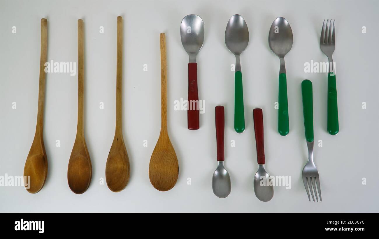 Cucchiai in metallo e legno, forcelle, legno su fondo bianco, utensili da cucina Foto Stock
